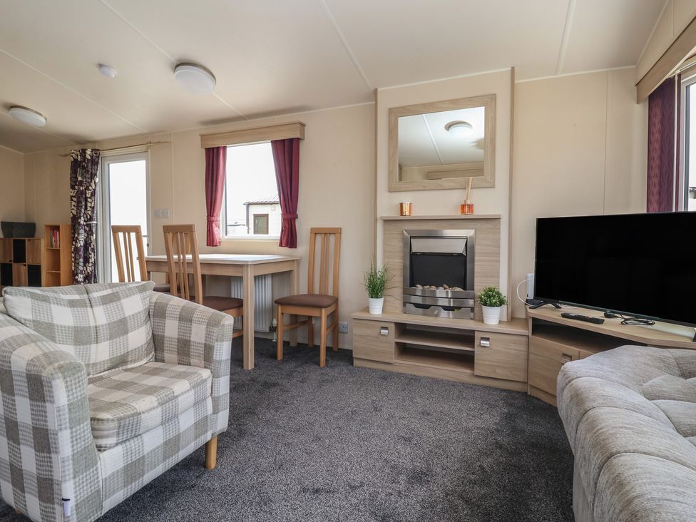 A living room with a table and chairs at Paws and Relax