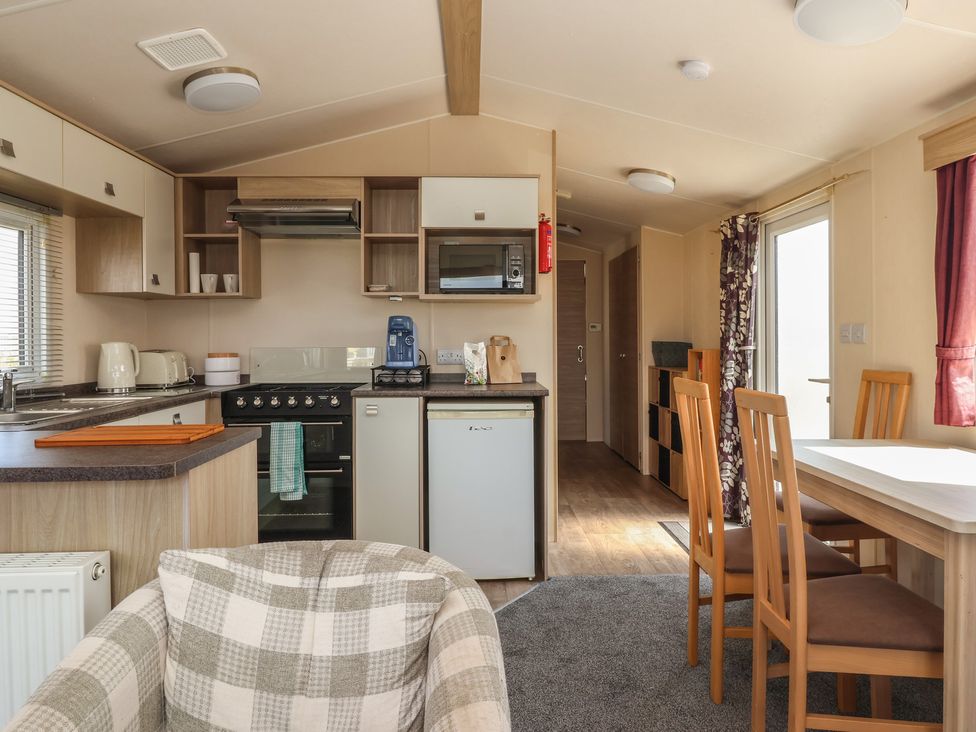 A kitchen with appliances and dining area at Paws and Relax