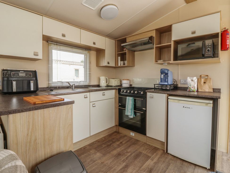 A kitchen with appliances and storage at Paws and Relax 