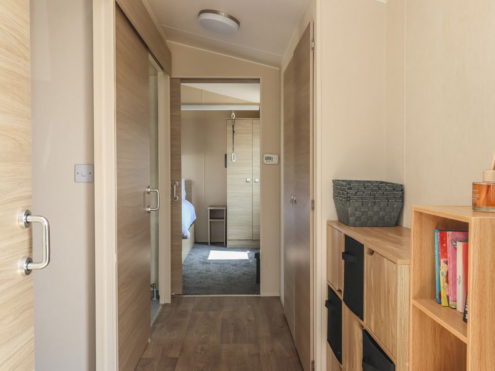 A hallway with shelves and doors at Paws and Relax 