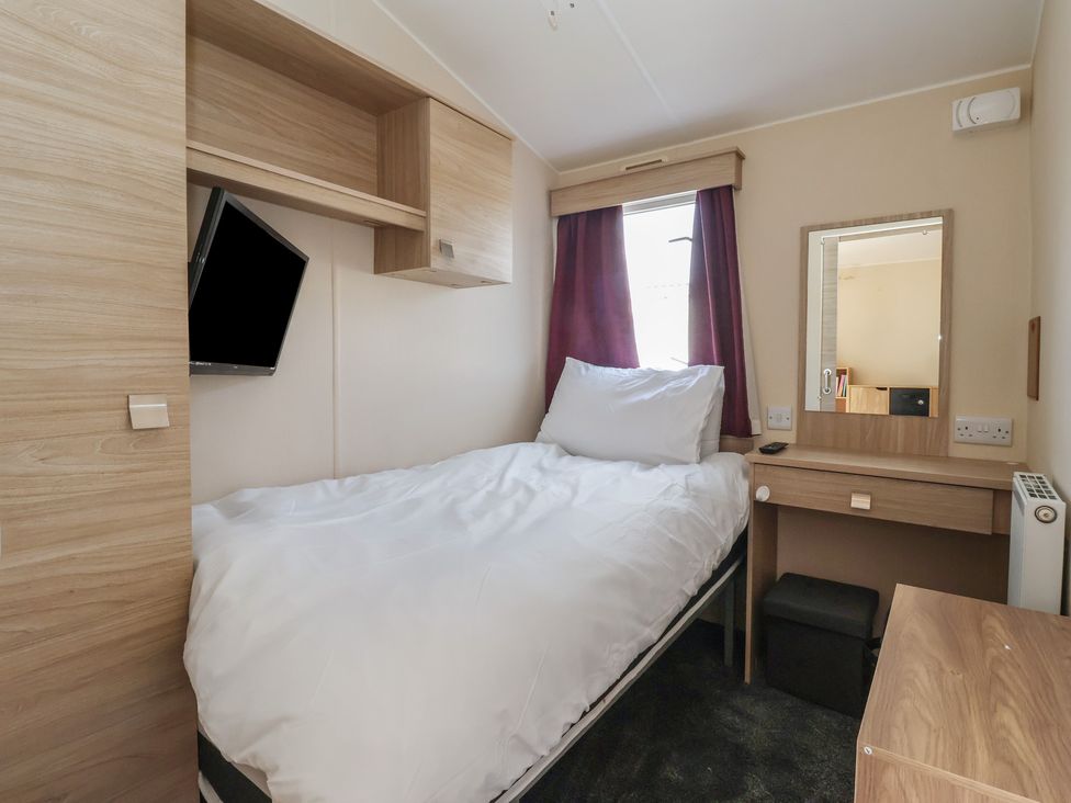 A bedroom with a bed, television, and desk at Paws and Relax