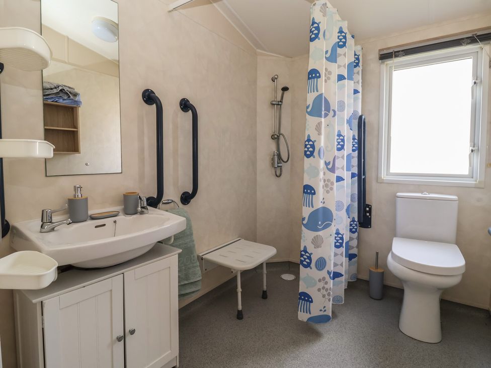 A bathroom with a shower, sink, and toilet at Paws and Relax