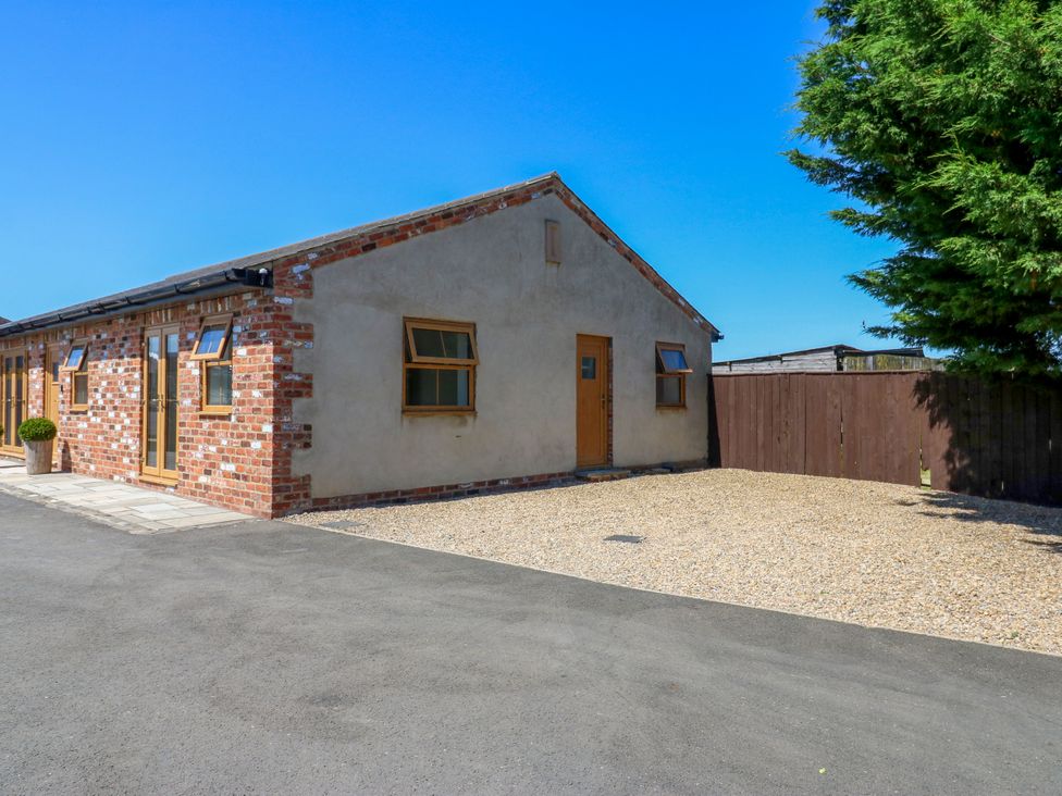 A house with brick walls and a gravel driveway at Black Banks Farm Cottage in Darlington