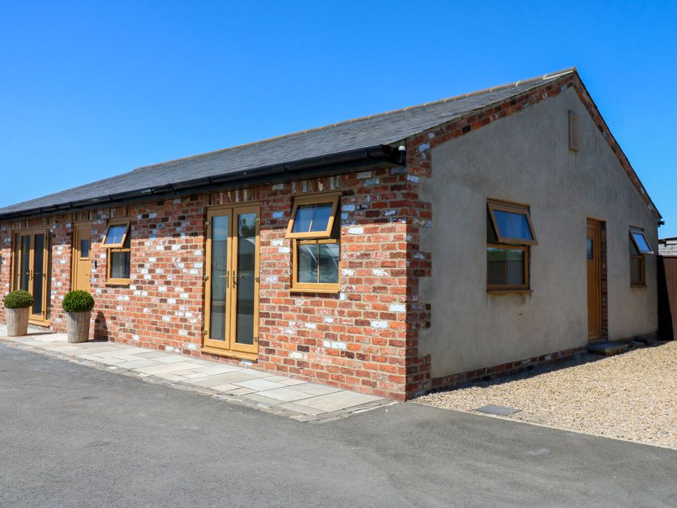 An exterior view of a cottage with brick walls and wooden features at Black Banks Farm Cottage Darlington