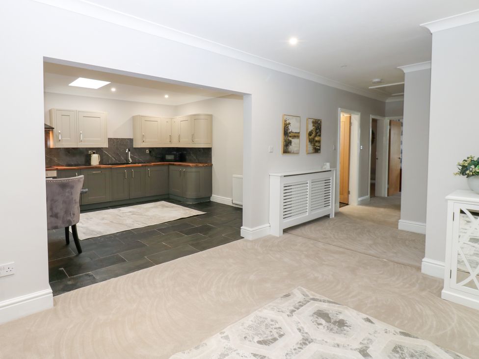 A kitchen with cabinets and a table at Black Banks Farm Cottage in Darlington
