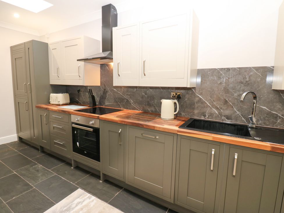 A kitchen with cabinets and appliances at Black Banks Farm Cottage in Darlington