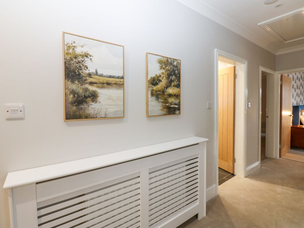 A hallway with paintings and a radiator at Black Banks Farm Cottage, Darlington