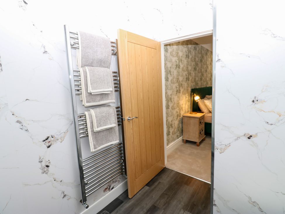 A bathroom with a towel radiator and a door leading to a bedroom at Black Banks Farm Cottage in Darlington