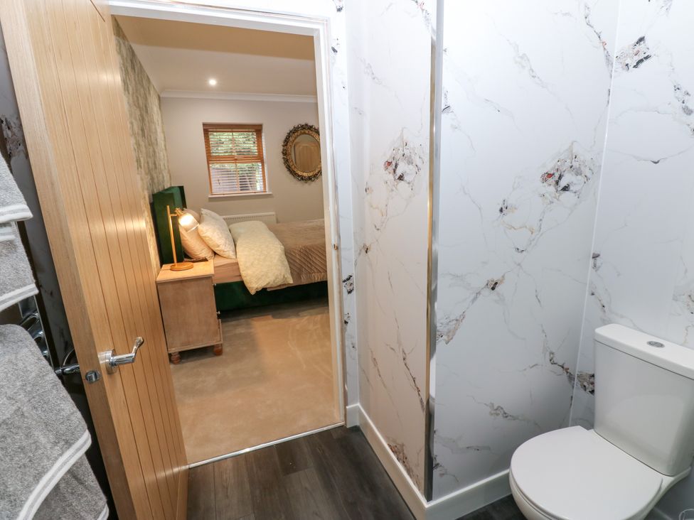A bathroom with a toilet view and an adjacent bedroom at Black Banks Farm Cottage in Darlington