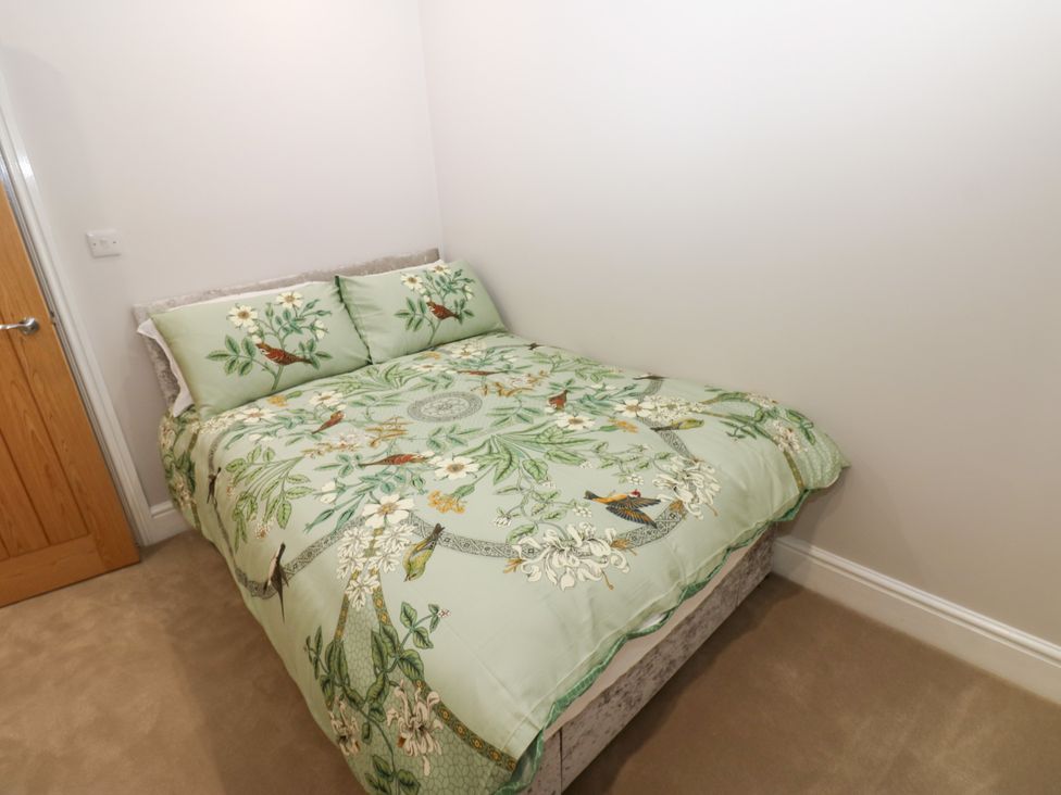 A bed with patterned bedding and pillows at Black Banks Farm Cottage, Darlington