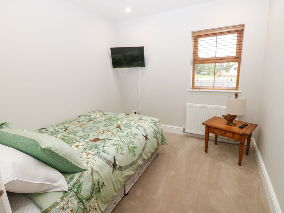 A bedroom with a bed and television at Black Banks Farm Cottage in Darlington