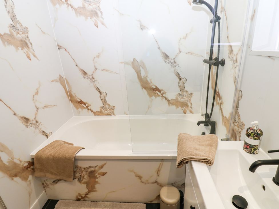 A bathroom with a bathtub and shower at Black Banks Farm Cottage in Darlington