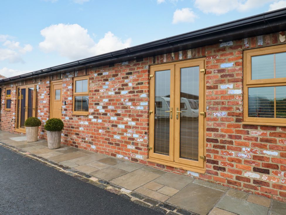 An exterior view of a building with brick walls and double doors at Black Banks Farm Cottage, Darlington