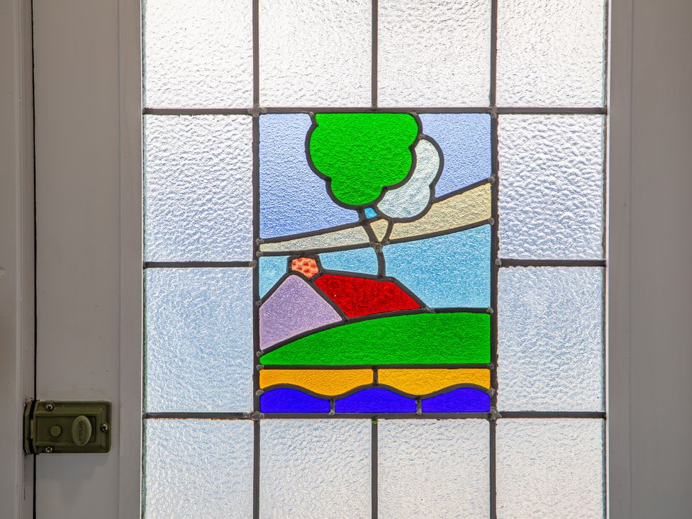 A stained glass window depicting a landscape at Hudson House