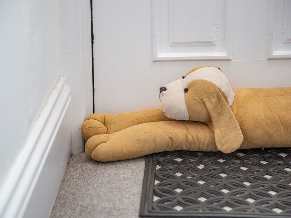 A stuffed dog positioned near a door at Hudson House