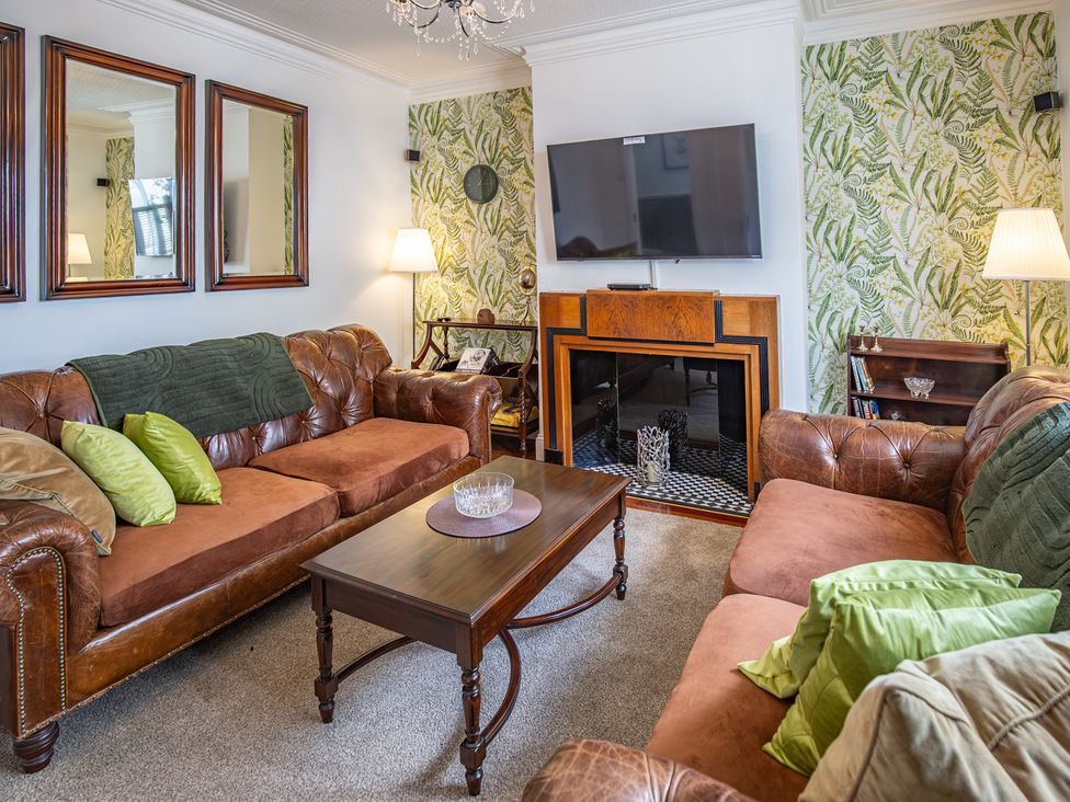 A living room with a sofa, coffee table, and television at Hudson House
