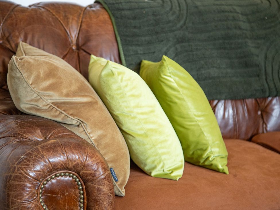 A sofa with cushions and a green throw blanket at Hudson House