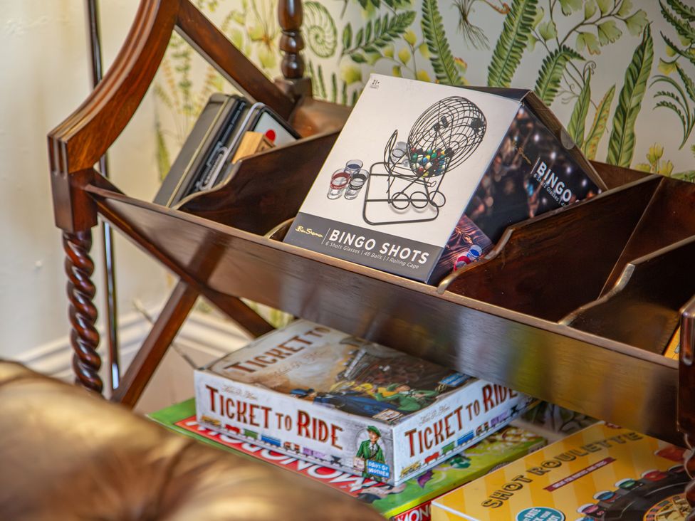 A shelf displaying a bingo set and board games at Hudson House