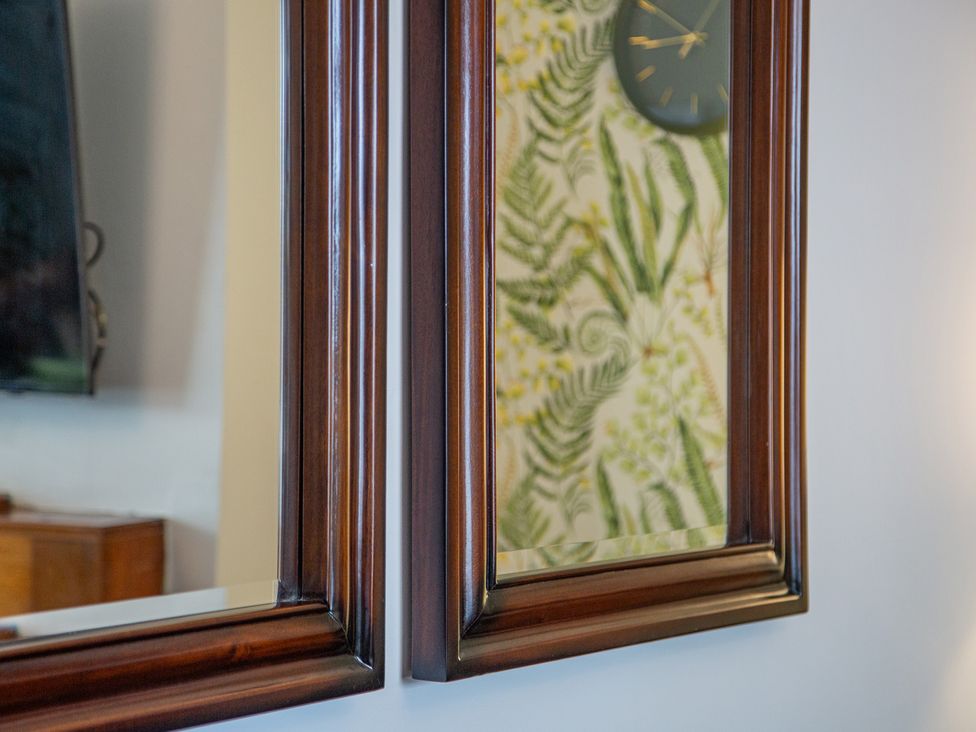 A mirror and clock on the wall in a living room at Hudson House