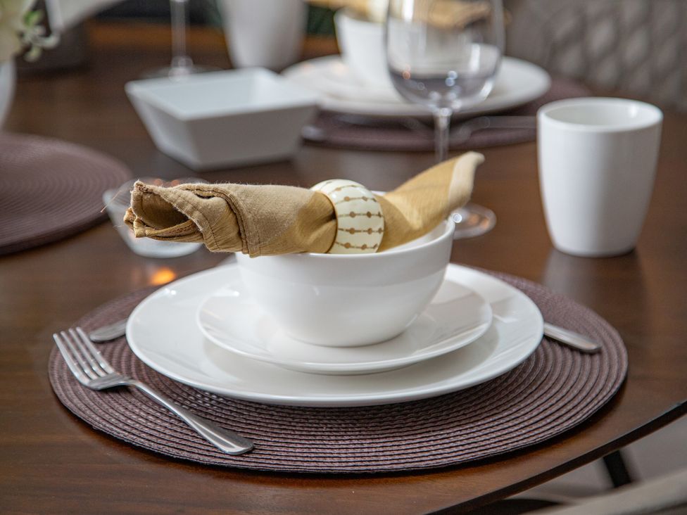 A dining table set with dishes and utensils at Hudson House