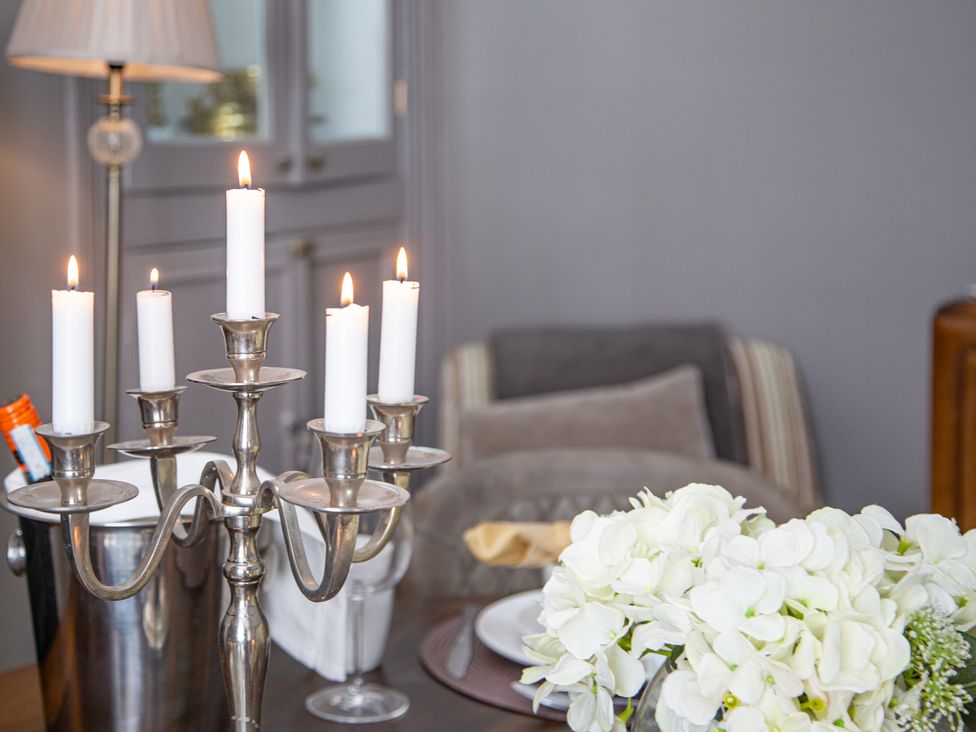 A dining room with candles on a table and a flower arrangement at Hudson House