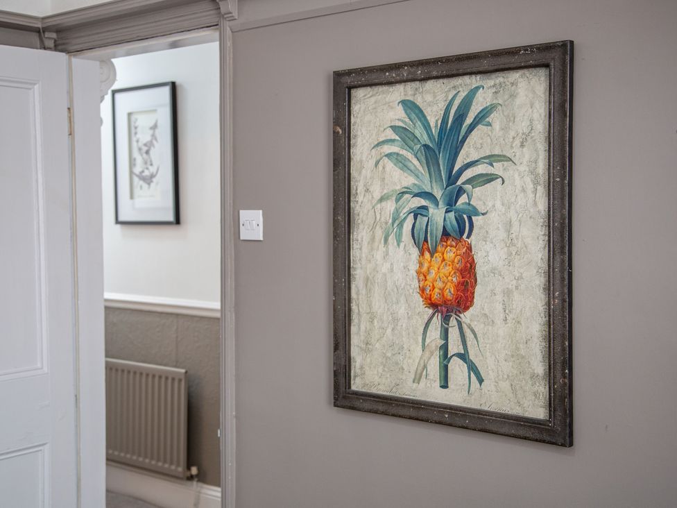 A pineapple artwork on the wall in a hallway at Hudson House