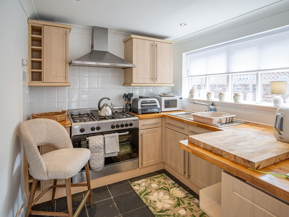 A kitchen with a stove, sink, microwave, and counter space at Hudson House