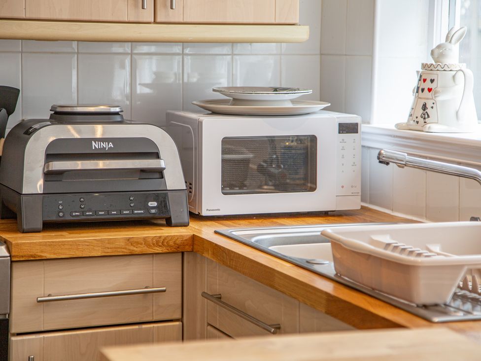 A kitchen with a Ninja oven and microwave on the countertop at Hudson House