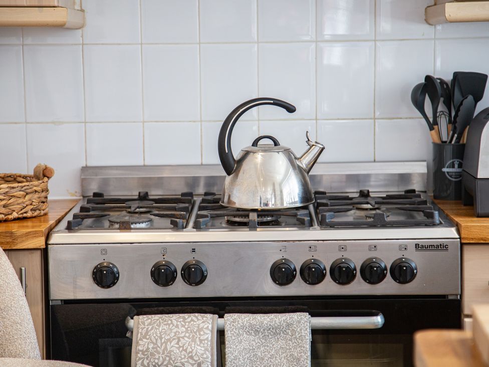 A gas stove with kettle and utensils at Hudson House