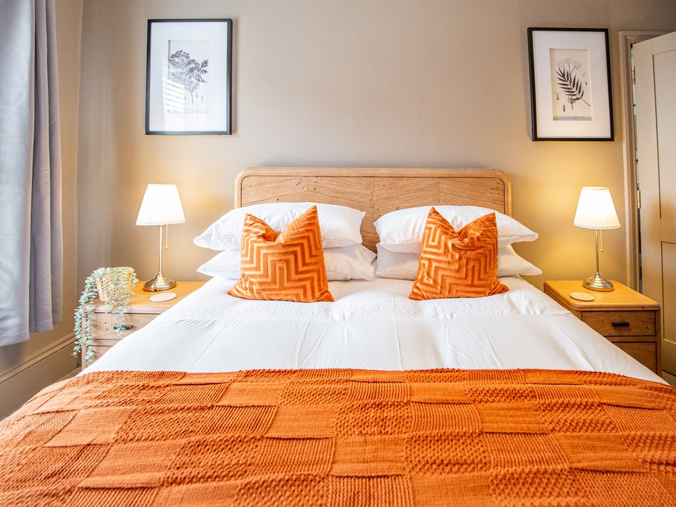 A bedroom with a bed and bedside tables at Hudson House