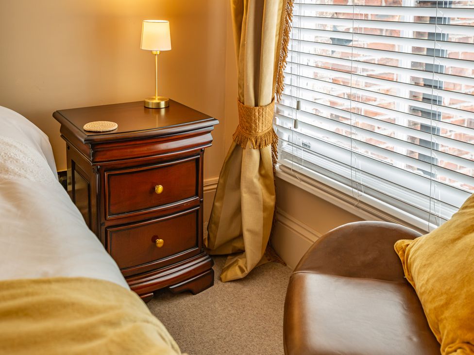 A bedroom with a nightstand and lamp at Hudson House