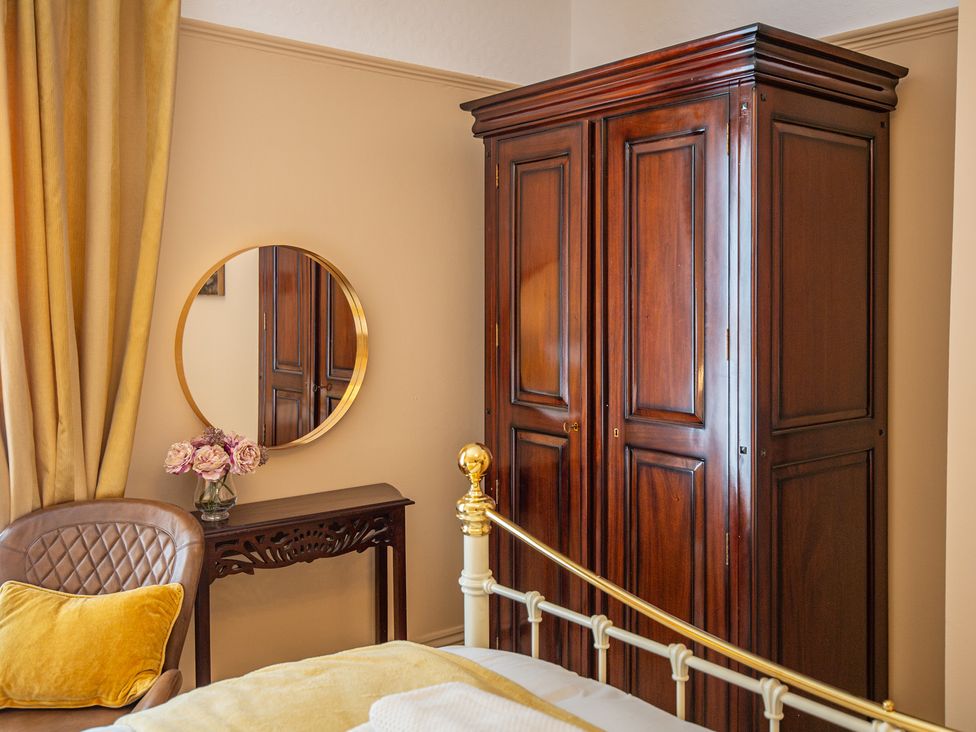 A bedroom with a wardrobe and mirror at Hudson House