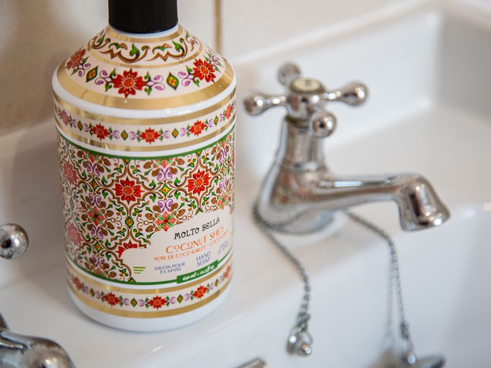 A soap dispenser and faucet on a sink in Hudson House
