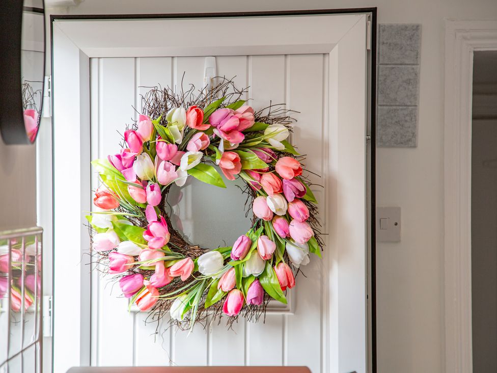 A wreath on a door with a mirror at Hudson House