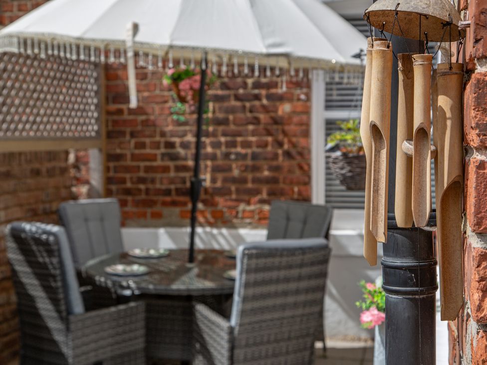 An outdoor seating area with a table and chairs under an umbrella at Hudson House