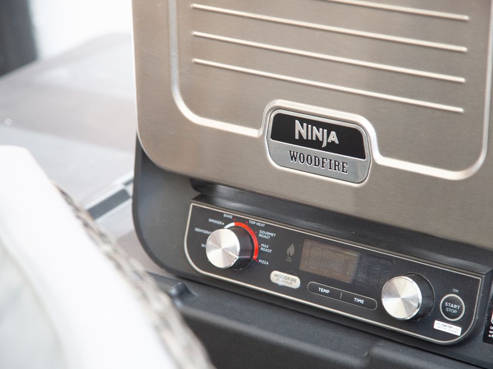 A Ninja woodfire grill with temperature and time controls outside at Hudson House