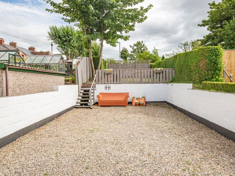 A garden with gravel, steps, and a sofa at Hudson House