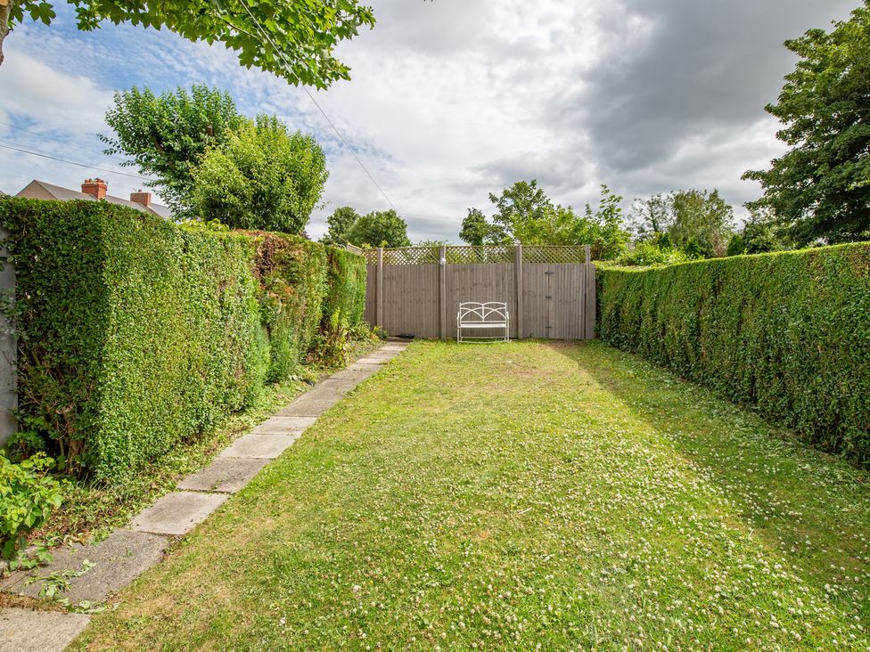 A garden with a bench and hedges at Hudson House in 