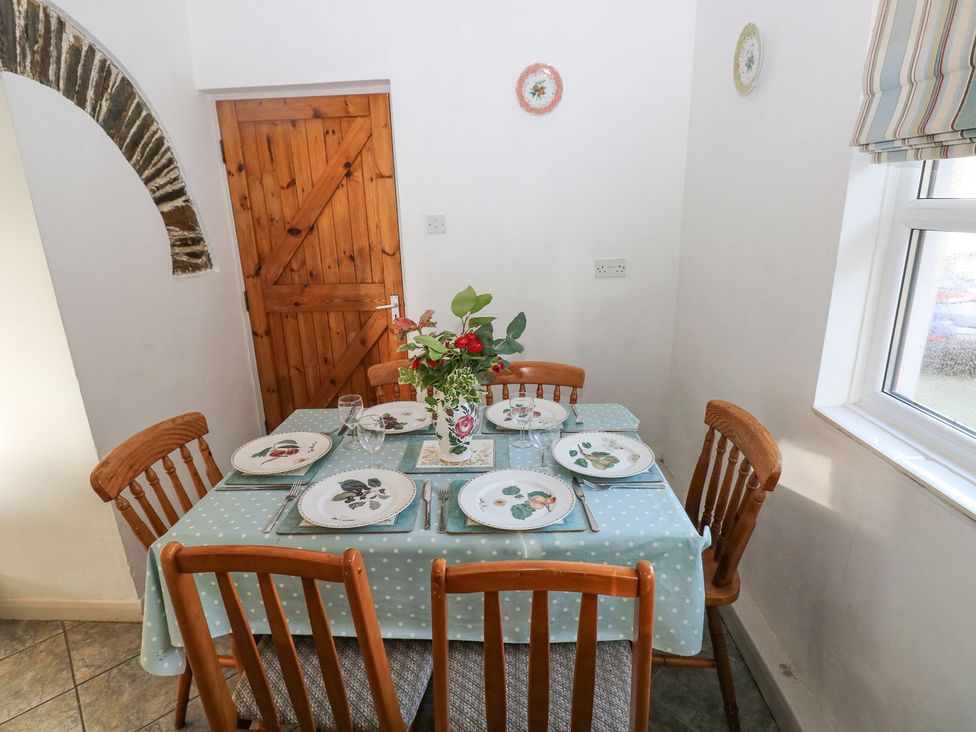 A dining room with a table set for a meal at Barn Cottage in Haverfordwest