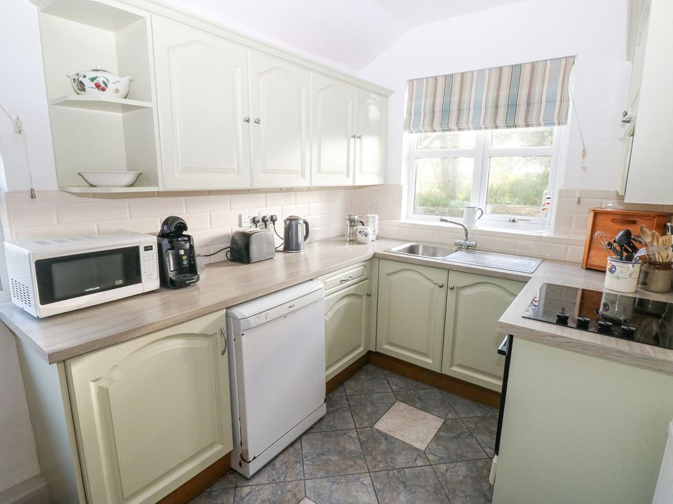 A kitchen with appliances and cabinets at Barn Cottage in Haverfordwest