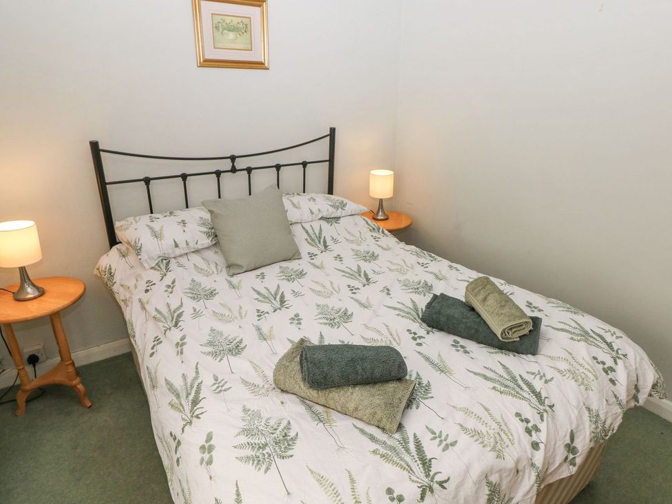A bedroom with a bed and lamps at Barn Cottage in Haverfordwest