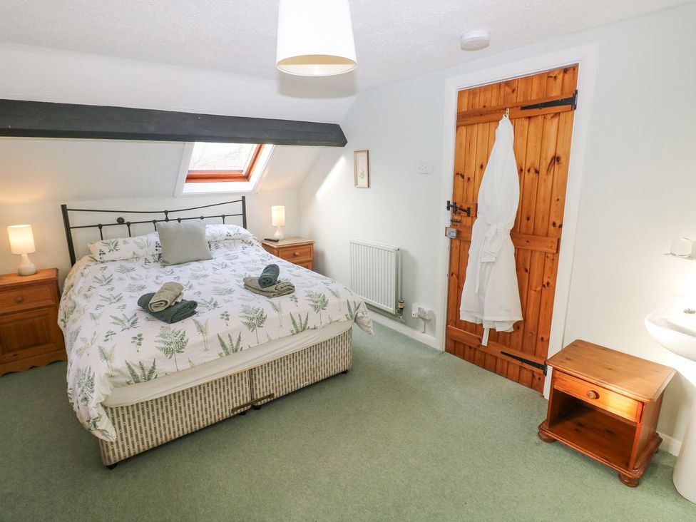 A bedroom with a bed and wooden furniture at Barn Cottage in Haverfordwest