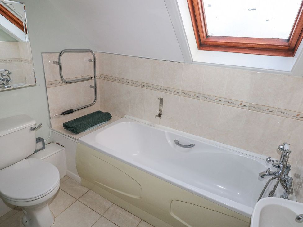 A bathroom with a bathtub and toilet at Barn Cottage in Haverfordwest