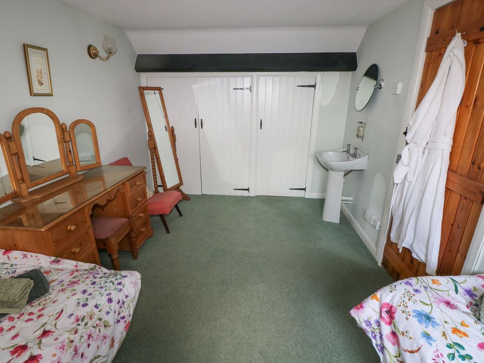 A bedroom with a dressing table and sink at Barn Cottage Haverfordwest