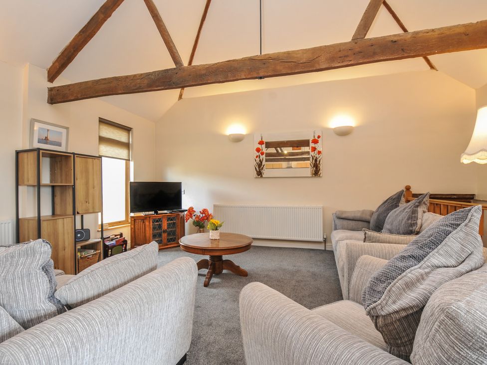 A living room with a coffee table and sofas at The Old Wagon House in Torpoint