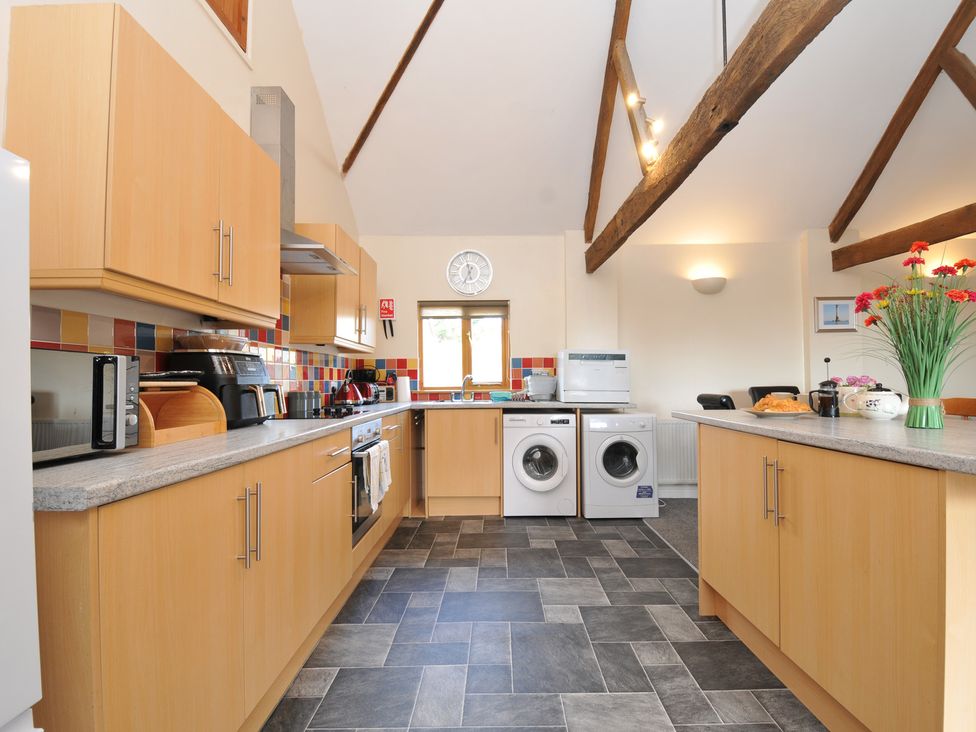 A kitchen with countertops and appliances at The Old Wagon House in Torpoint