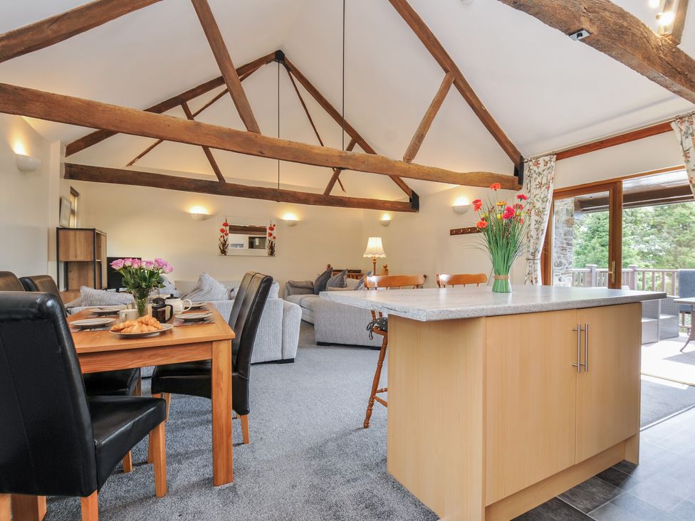 A living room with a dining table and seating area at The Old Wagon House in Torpoint