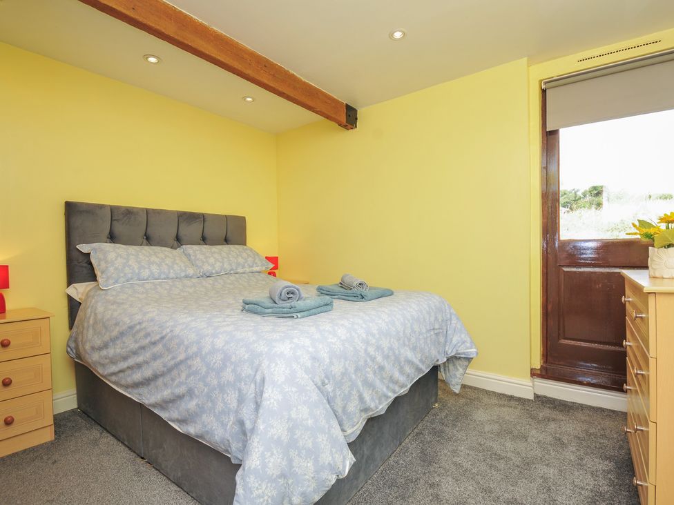 A bedroom with a bed and dresser at The Old Wagon House in Torpoint