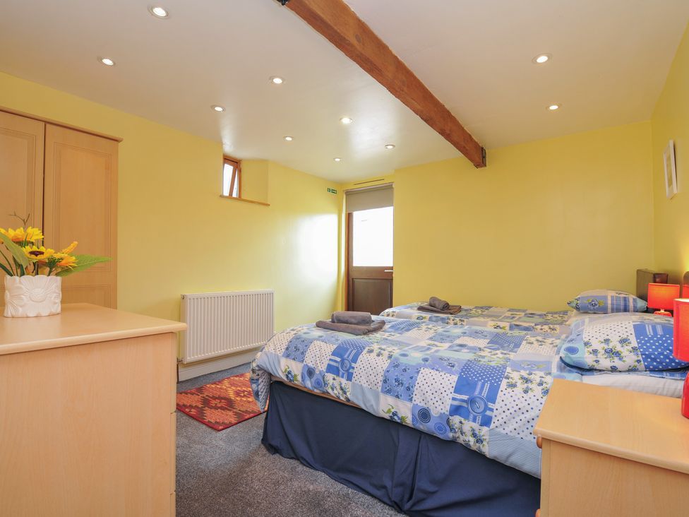 A bedroom with a bed and wardrobe at The Old Wagon House in Torpoint