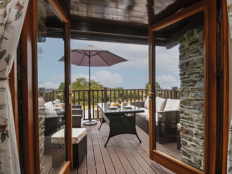 A balcony with a table and chairs at The Old Wagon House in Torpoint